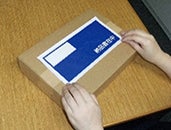 ①伝票を入れてから片方のはく離紙を剥がして箱に貼り付けます。